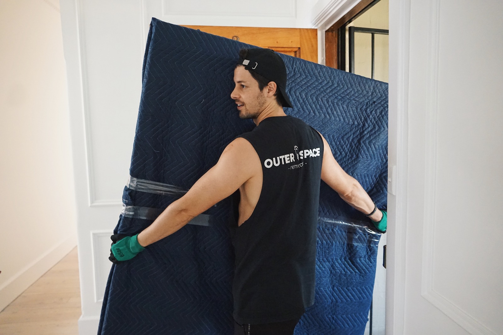 Outer Space Removals mover protecting a doorway with a moving blanket