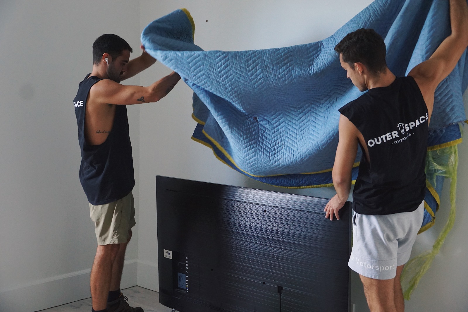 Outer Space Removals mover wrapping a TV