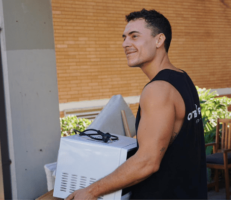 Smiling mover carrying an appliance